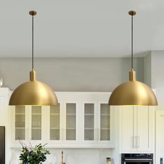 two brass pendant lights hang over a kitchen island