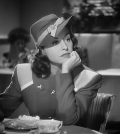 a woman sitting at a table with food in front of her