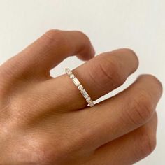 a woman's hand with a diamond ring on top of her finger and the other hand holding it