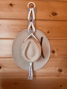 a cowboy hat hanging on the wall next to a pair of scissors and a hook