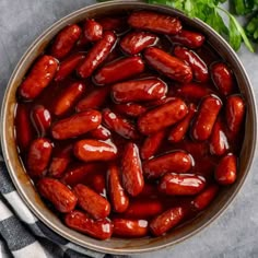 hotdogs are cooked in a pan with ketchup on the side and garnished with parsley