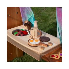 a child's wooden picnic table with food on it