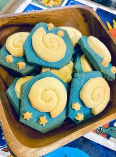 blue and yellow decorated cookies in a wooden bowl