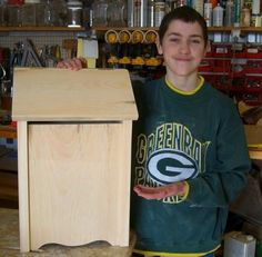 a young boy standing next to a wooden podium