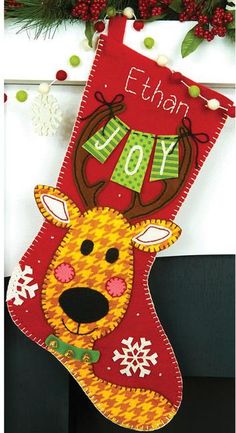 a christmas stocking hanging from the fireplace with a reindeer on it's head