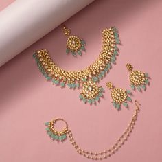 Description: This Kundan bridal set is elegant and beautiful. Encrusted with Kundan stones and a cascade of sea-green beads, this jewelry set is a perfect complement to your wedding or festive look. Crafted in the gold-plated alloy, this necklace comes with matching complimentary embellished Jhumki earrings, nose ring & maang Tikka which can be worn together or as separate pieces. Details & Specifications: Materials used: Brass Alloy with Matte Gold Plating Make it custom Want to make it a custo Green Kundan Bridal Sets For Celebration, Gold Jeweled Jewelry Sets For Reception, Turquoise Temple Jewelry For Wedding, Green Jeweled Wedding Jewelry, Gold Plated Stone Work Jewelry Sets For Weddings, Gold Plated Jewelry Sets With Stone Work For Wedding, Gold Plated Wedding Jewelry Sets With Stone Work, Festive Turquoise Bridal Necklace For Wedding, Festive Turquoise Bridal Necklace