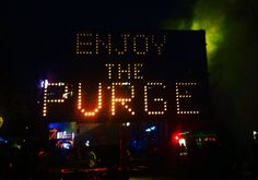 a sign that says enjoy the journey in front of a building with lights on it