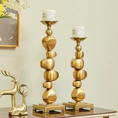 two gold candlesticks sitting on top of a table