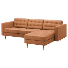 a brown leather sectional sofa sitting on top of a white floor next to a footstool