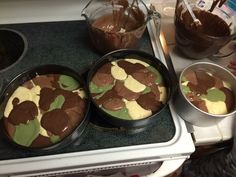 three pans filled with chocolate pudding on top of a stove