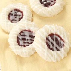 three cookies with white icing and jelly on them