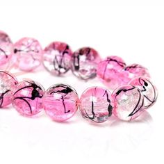 pink and black glass bead bracelet with silver accents on white background, closeup