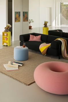 a living room filled with lots of furniture and decor on top of a carpeted floor