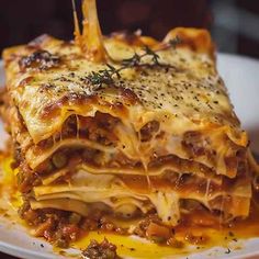 a white plate topped with lasagna covered in cheese