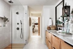 a bathroom with two sinks, mirrors and a shower stall in it's center