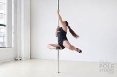 a woman is doing aerial acrobatics on a pole