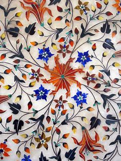 an intricately designed tile with flowers and leaves