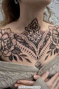 a woman's chest with flowers on it and an intricate design in the middle