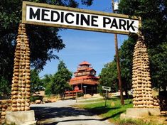 a sign that says medicine park in front of some trees