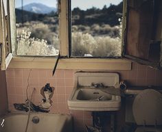 an old run down bathroom with broken windows