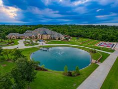 an aerial view of a mansion with a large pond