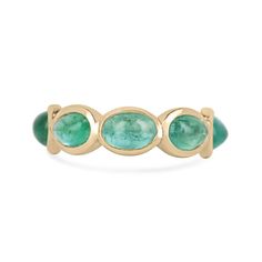 Introducing our exquisite Emerald Cabochon Eternity Band Ring, a timeless masterpiece for your collection. Seven alluring oval-shaped cabochon-cut emeralds, boasting a lush medium green color and semi-transparent clarity, elegantly encircle the band in individual bezel settings. Crafted in luxurious 14k gold, this ring is designed with both style and durability in mind, featuring a thoughtful gap at the bottom to ensure comfortable wear while safeguarding the precious gemstones. Available in size 6.5, this ring is a symbol of enduring elegance and sophistication. Setting Style: Bezel  Setting Material: 14K Gold Setting Weight: 3.0 Grams Main Stone: Emerald Shape: Oval  Count: 7 Weight: 3.60-Carats (Total) Clarity: Semi-Transparent  Color: Lush Medium Green Luster: Good Treatments: Natural, Oval Yellow Gold Emerald Ring With Multi-stone, Oval Yellow Gold Emerald Ring With Multiple Stones, 14k Gold Emerald Cabochon Ring For Anniversary, Yellow Gold Oval Cabochon Gemstones For Anniversary, Classic Oval Stackable Emerald Ring, Emerald Bezel Set Oval Cabochon Ring, Three Stone Oval Cabochon Rings For Anniversary, 14k Gold Multi-stone Oval Cabochon Ring, Green Oval Bezel Setting Stackable Rings