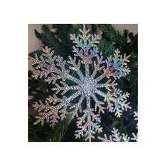 a snowflake hanging from the side of a christmas tree