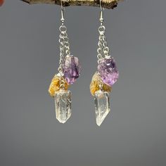 "Multi Stone Cascade Long Dangle Earrings, Amethyst Citrine Quartz Long Crystal Earrings You will receive 1 (ONE) Pair of Multi Stone Cascade Long Dangle Cluster Earrings Item Description: Stone: Quartz, Amethyst, Citrine  Metal: Plated Brass Shape: Point Size: 2\"- 2.5\" by 0.50\"  Chain: Cable Drop length: About 2.5 inches  Clasp: Ear Wire Enhance your style with these stunning Long Dangle Earrings featuring three powerful stones: Citrine, Amethyst, and Quartz. Handcrafted with love, these ear Amethyst Dangle Crystal Earrings With Natural Stones, Amethyst Natural Stone Dangle Crystal Earrings, Crystals Citrine, Long Crystal Earrings, Long Dangle Earrings, Cluster Earrings, Raw Crystal, Stylish Gifts, Multi Stone