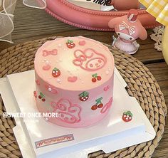 a pink cake sitting on top of a wooden table