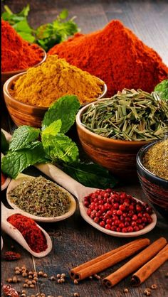 various spices and herbs in bowls on a table