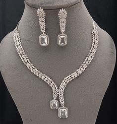 Faux CZ Diamonds White Necklace Earrings Set, Bridal Dangler Earrings, Bridal Choker, Party Wear Silver Necklace Earrings, Statement Piece ITEM DESCRIPTION Metal        = Silver Plated Occasion  = Wedding, Party Wear, Bridal Color        = White and Silver Size          = Necklace Length = 7 Inches Long, Earring Size = 2.5 Inches Long,  Free Shipping 100% Satisfaction Guarantee: 1 Year Warranty, Long Lasting Plating, High-Quality Stones Occasion: Perfect choice for any Indian occasion.  Care: It Hand Set Diamond White Jewelry Sets For Party, Diamond White Hand-set Jewelry Sets For Party, Party Jewelry Sets With Matching Drop Earrings, Cubic Zirconia Dangle Bridal Necklace For Party, Hand Set Teardrop Jewelry For Party, Hand Set Drop Earrings For Party, Dazzling Diamond White Jewelry Sets For Party, Teardrop Necklace With Matching Earrings For Parties, Party Teardrop Necklace With Matching Earrings