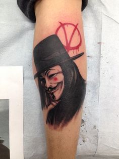 a man with a top hat on his head and a clown face tattooed on his arm