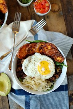 a bowl filled with meat, rice and an egg