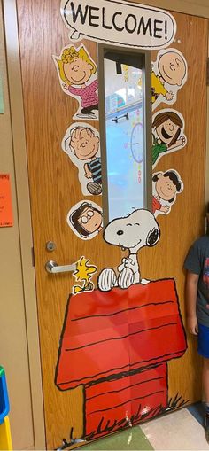 a child standing in front of a door decorated with peanuts