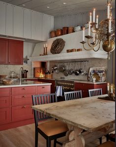 a kitchen with red cabinets and wooden table