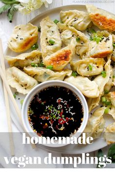 homemade vegan dumplings on a white plate with dipping sauce and chopsticks