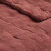 an image of a bed that has been made with pink sheets and blankets on it