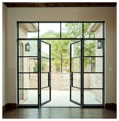 an open glass door leading to a brick building