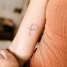 a small elephant tattoo on the left arm