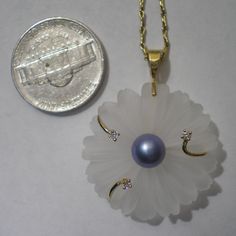 What a pretty pendant and ready for Spring and Summer. Pendant hangs 1 3/8 inches long and 1 1/8 inch wide. Hangs from a 14k bail with tendrils that clasp carved Rock Crystal and have three diamond accents (.05 cttw) on the ends. The center has a 7 mm purple blue pearl, not sure if this is a fresh water pearl but that is what I will go with. I have added this 18 inch 14k chain that itself is 2.9 grams and has a needle eye detail link, very nice and adds more interest to this pretty piece. Total Anniversary Flower Pendant Jewelry With Hallmark, Vintage Flower Pendant Gemstone Jewelry, White Crystal Flower Pendant Necklace, Luxury Pearl Flower Pendant Jewelry, Elegant Flower-shaped Pearl Pendant Necklace, White Flower-shaped Pearl Pendant Necklace, Eye Details, Pretty Pendant, Mother Birthday Gifts