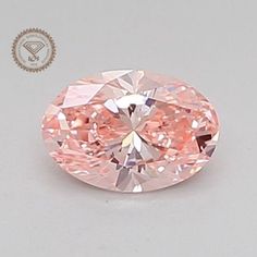 an oval shaped pink diamond on a white surface