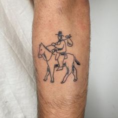 a man with a cowboy hat on his head riding a horse and holding a lasso