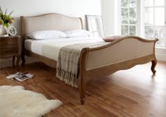 a bed sitting on top of a hard wood floor next to a white wall and window