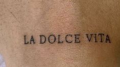 the word la dolce vita written in black ink on a person's arm