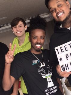 three young men posing for the camera with one holding up a sign that says teeth pop whine