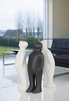 two black and white vases sitting on top of a table