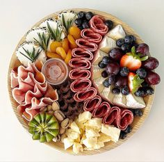 a platter filled with fruit, crackers and cheeses