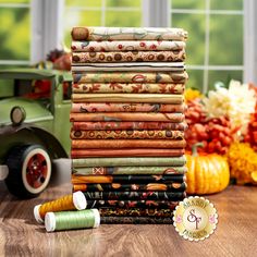 a stack of cloths sitting on top of a wooden table next to a green truck