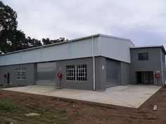 an industrial building with two garages on each side and one door open to let in light