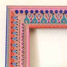 a pink frame with blue and orange designs on it